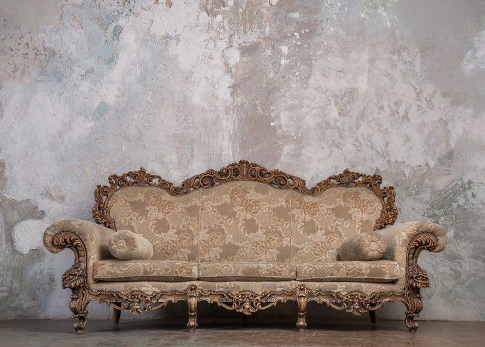 Antique sofa against old stucco background